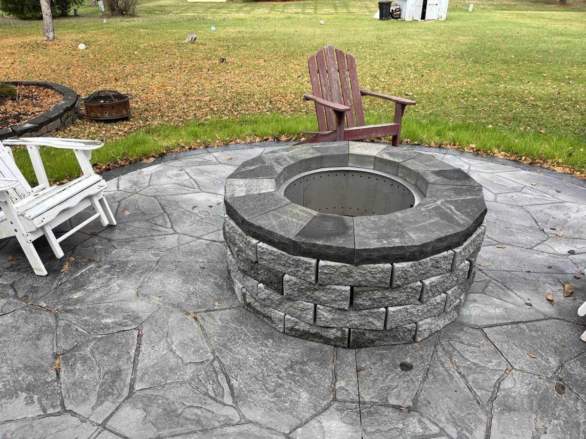 A fire pit patio ringed with chairs