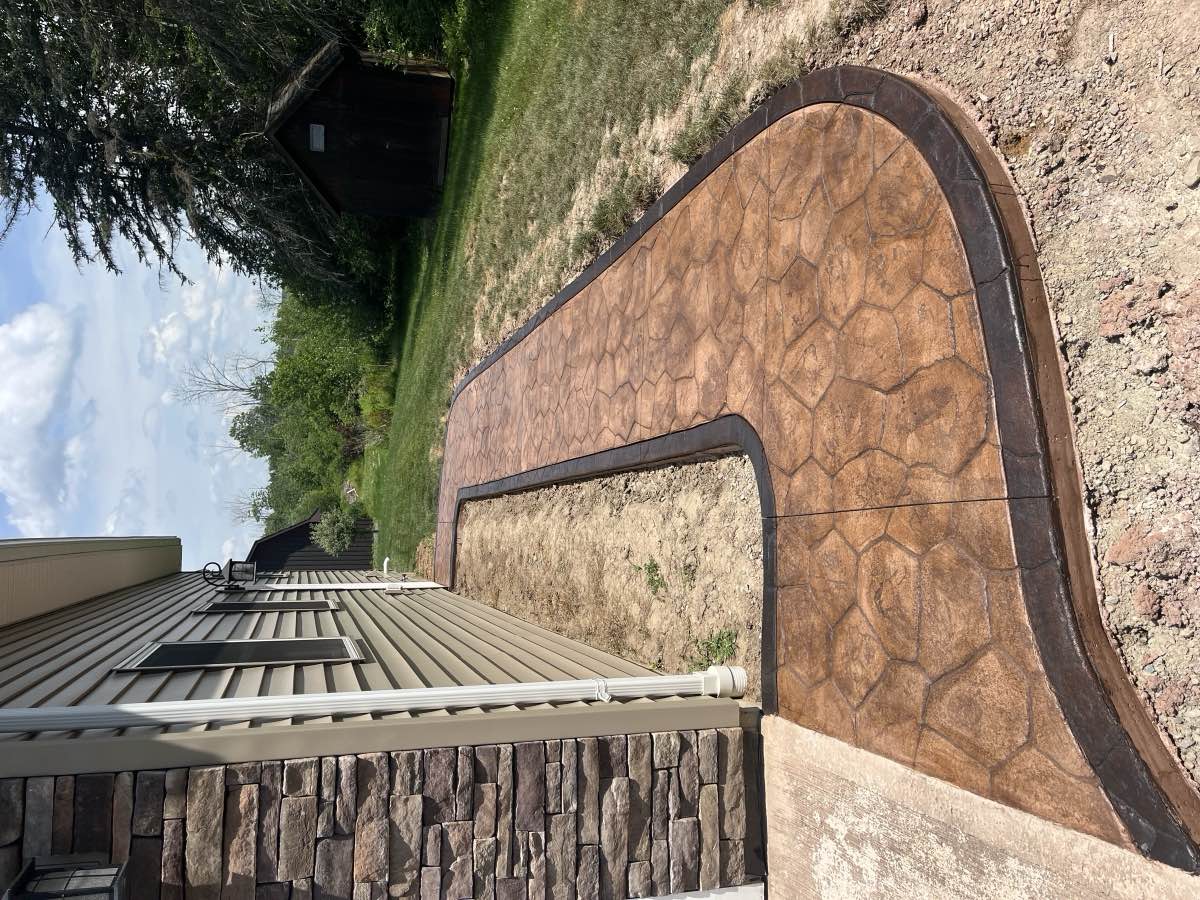 Side view of a curved concrete walkway along a home