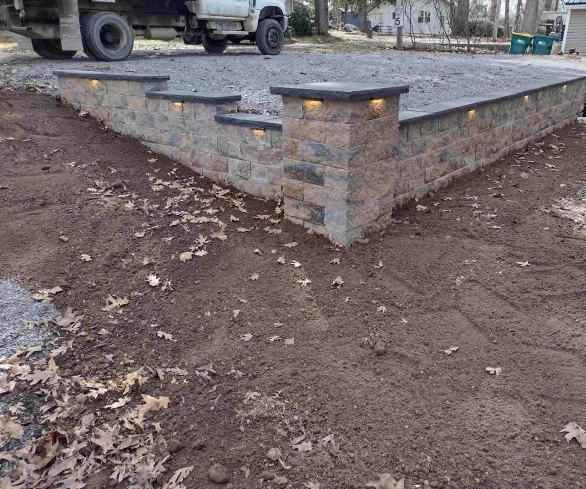 A retaining wall lit by low-voltage lighting at dusk