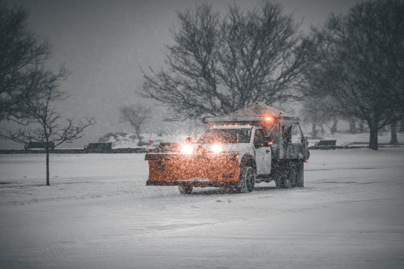 A plow truck clearing snow during a snowstorm